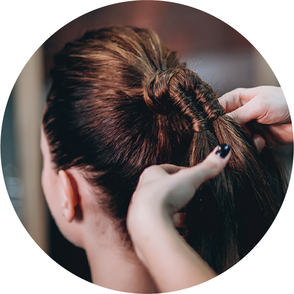 An image of a women getting her hair tied in a ponytail